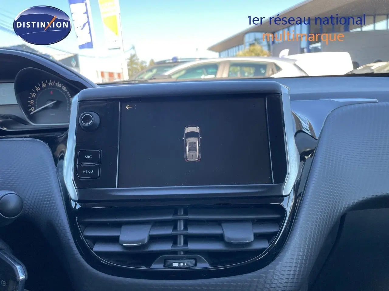 Vue rapprochée de l'écran tactile central et du tableau de bord en plastique texturé gris d'une Peugeot 2008 blanche.