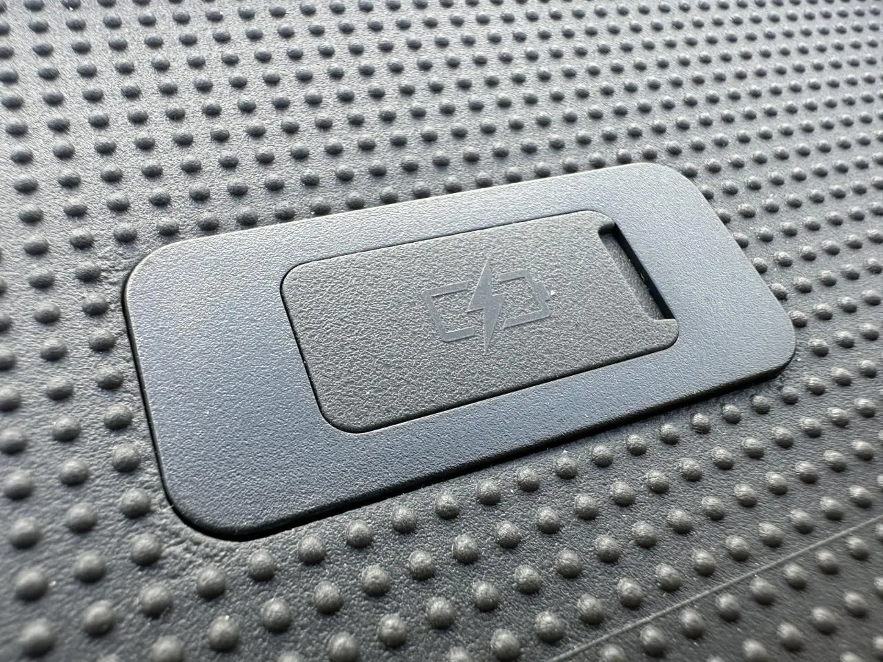 Gros plan sur un port USB avec symbole d'électricité sur la surface texturée du tableau de bord du Piaggio Porter blanc.