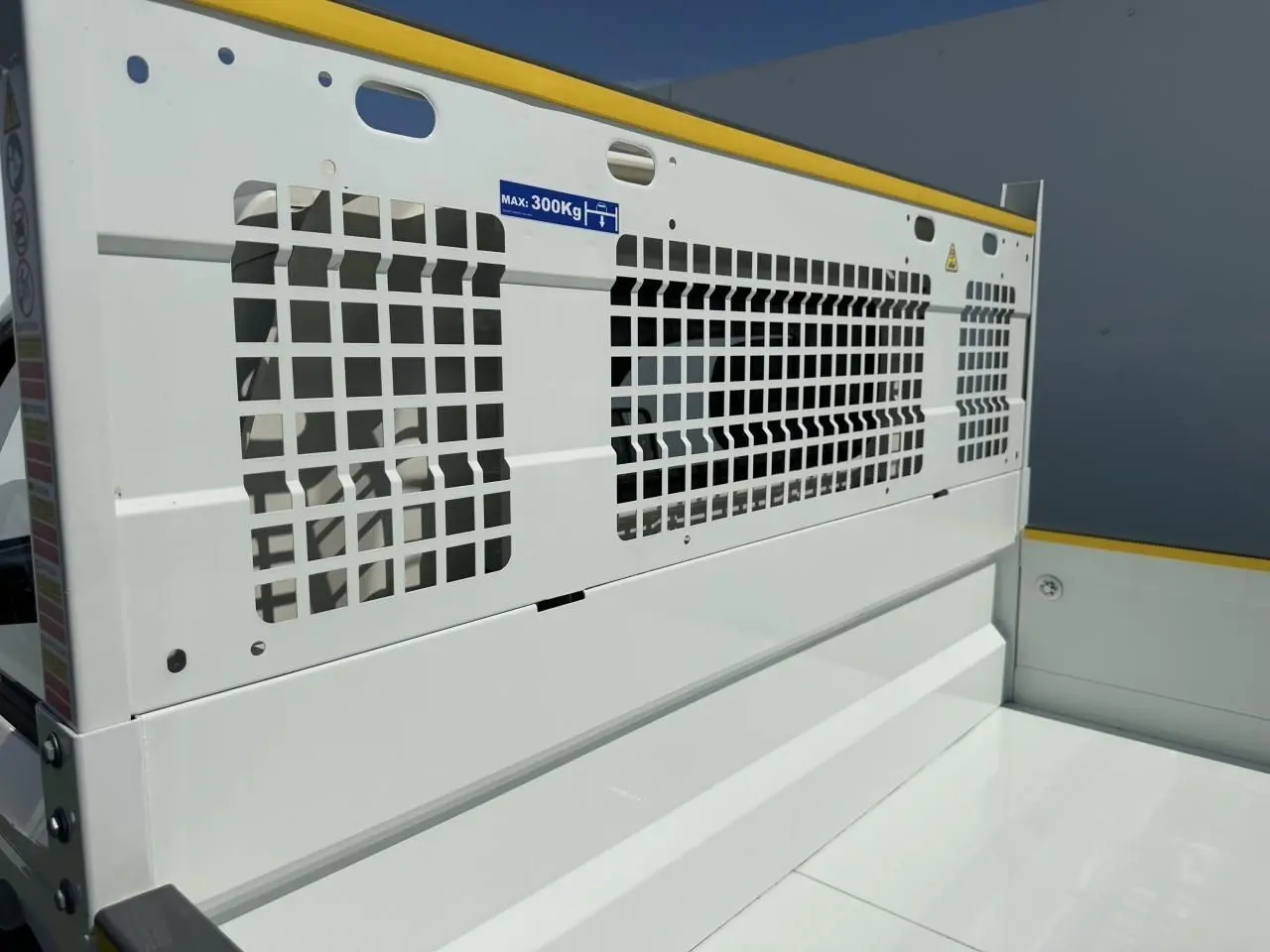 Détail de la benne blanche du Piaggio Porter 2024 vue de côté droit, avec grille de protection et marquage de charge maximale.