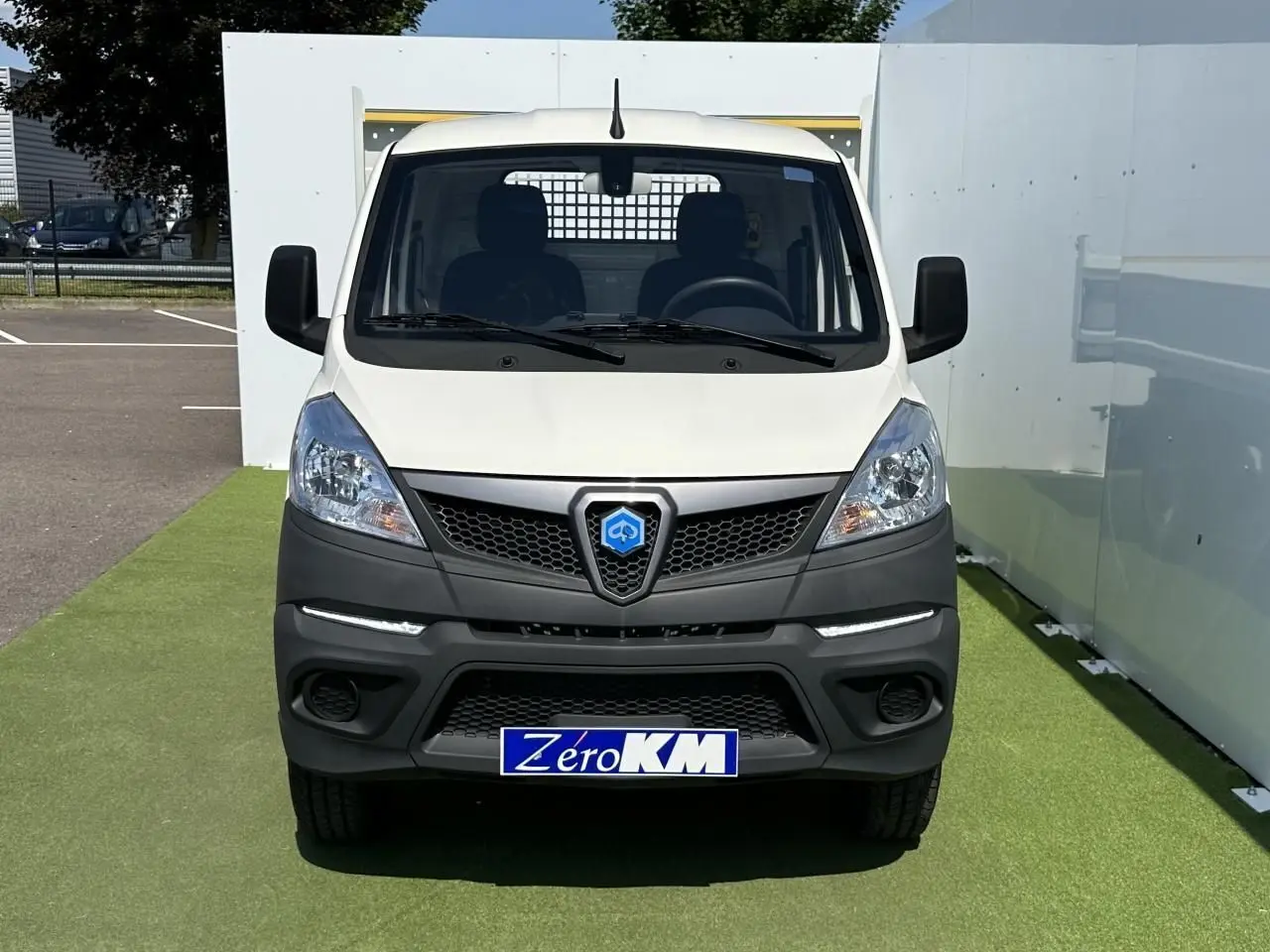 Vue de face du utilitaire blanc Piaggio Porter NP6 avec calandre noire et plaque d'immatriculation Zéro KM visible.