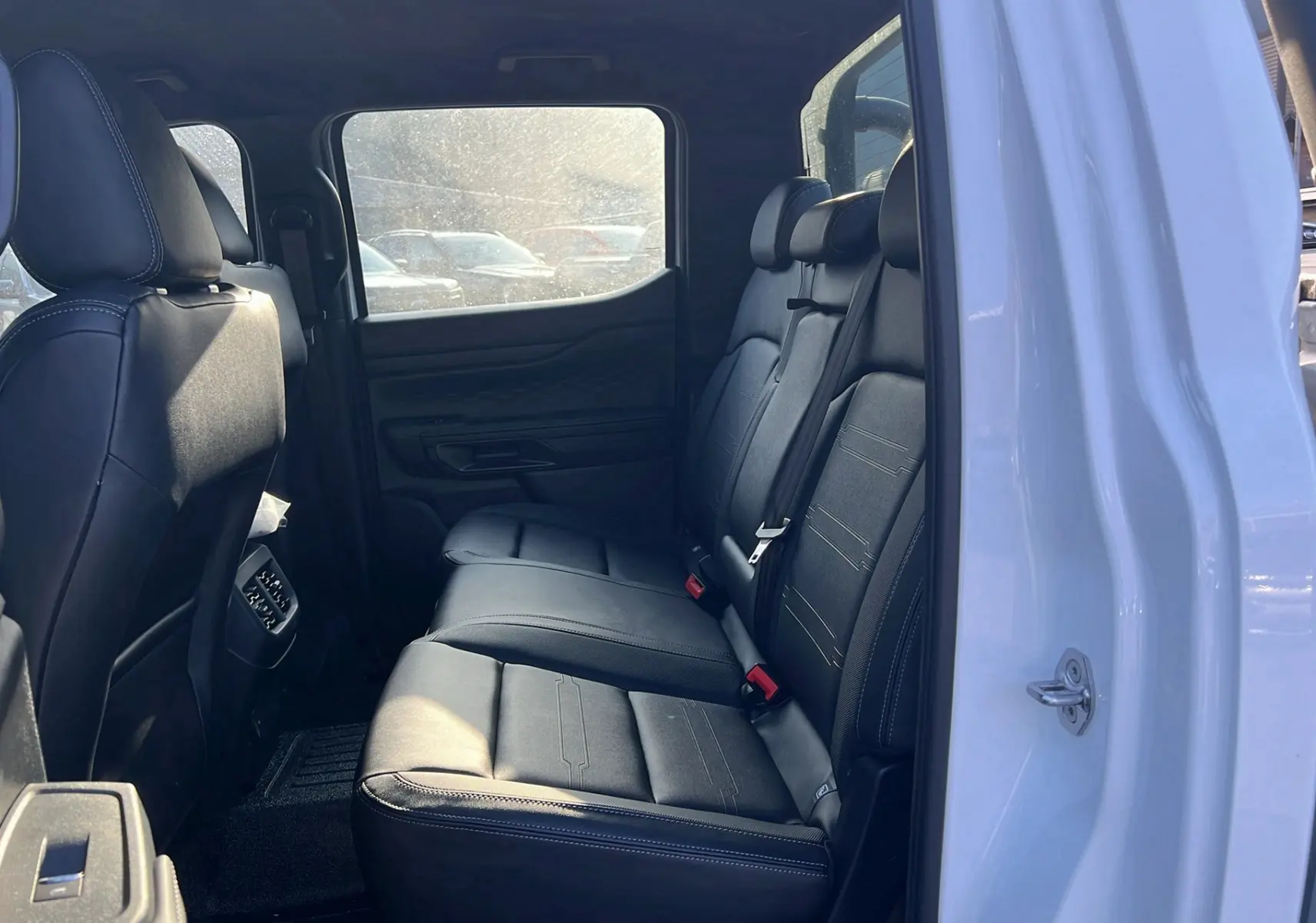 Vue intérieure côté droit sur la banquette arrière en cuir noir du Ford Ranger blanc glacier 2025 version Tremor Cover.