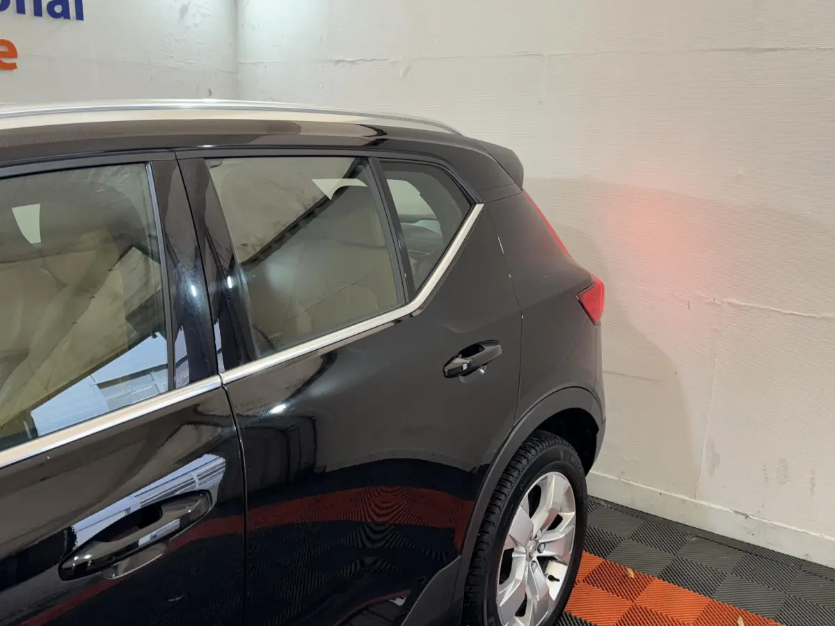 Vue côté droit arrière du Volvo XC40 noir Recharge T5 Inscription avec jante argentée et contour de vitre chromé.