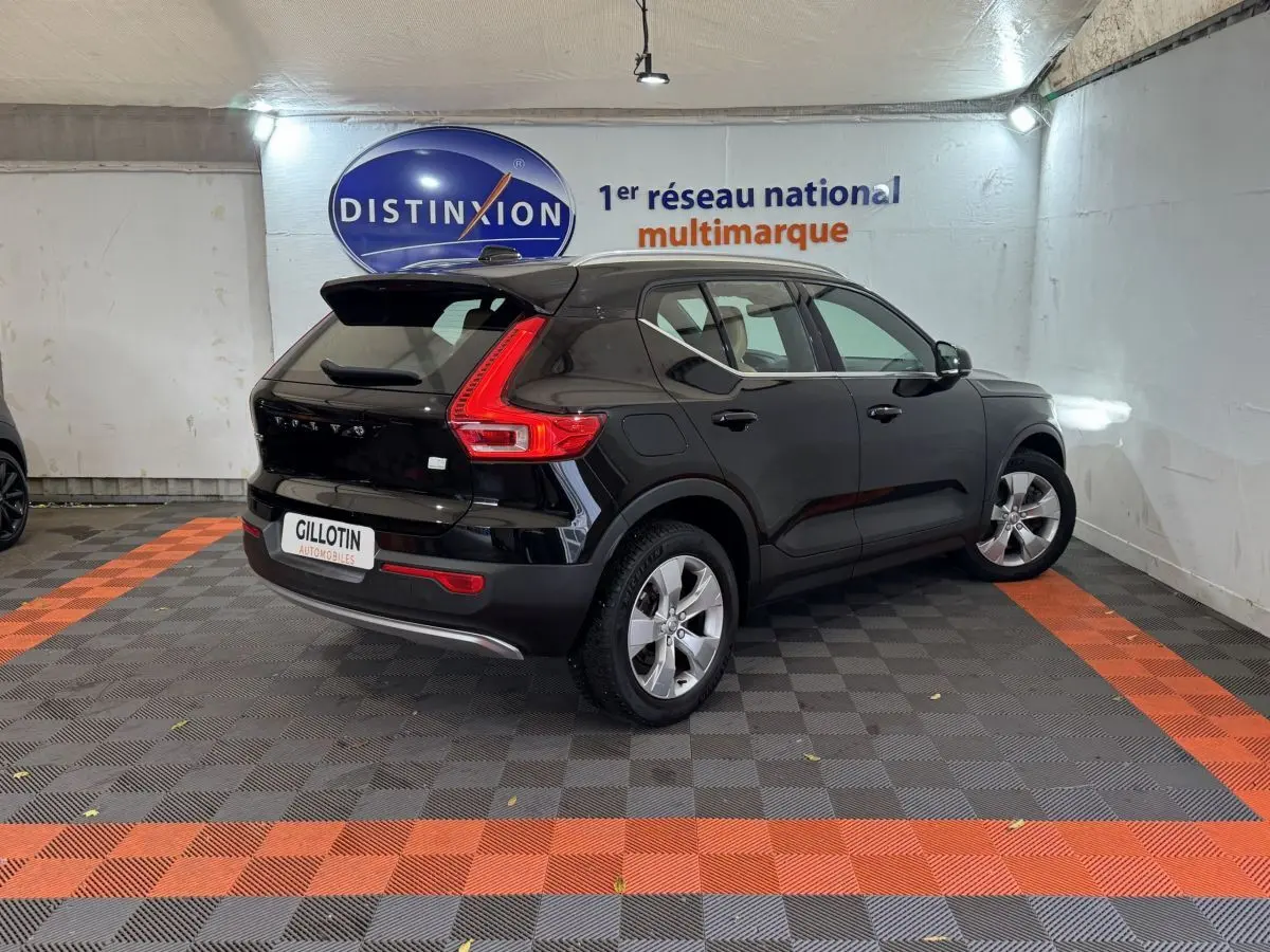 Vue 3/4 arrière droite d'un Volvo XC40 Recharge T5 noir, avec feux arrière en forme de L et jantes argentées.