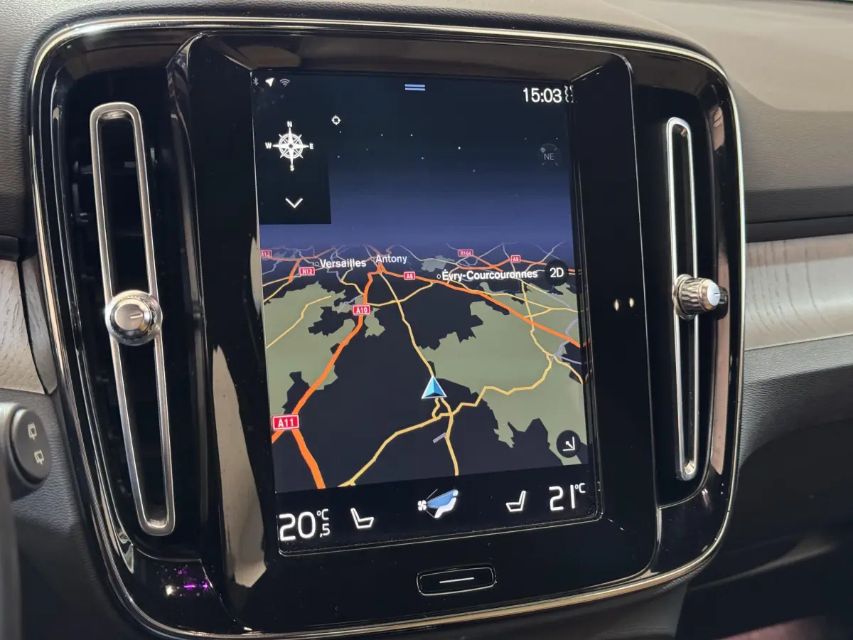 Vue rapprochée de l’écran tactile central noir du Volvo XC40 Recharge T5 affichant la navigation et la climatisation digitale.