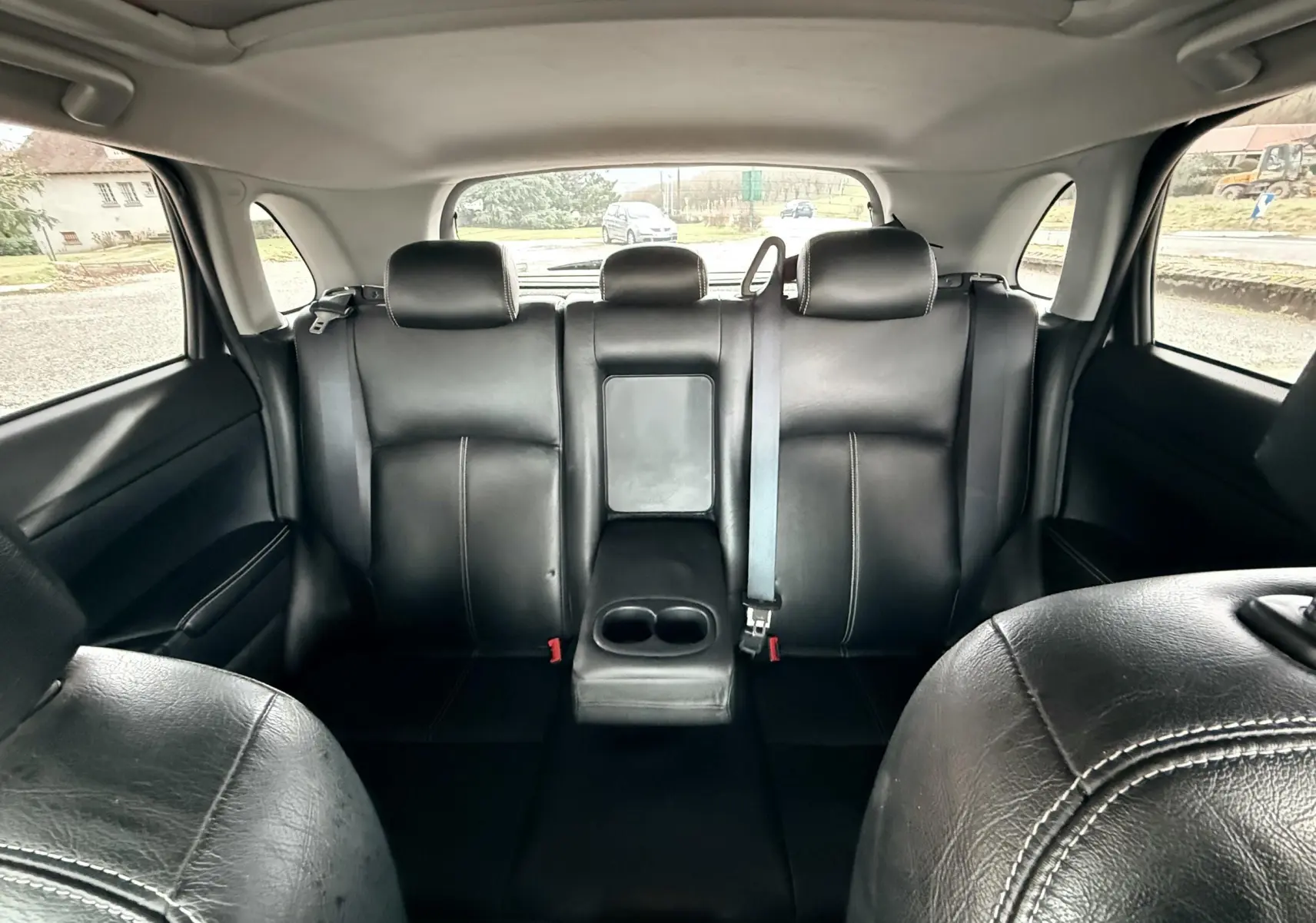 Vue intérieure arrière du Mitsubishi ASX 2015 montrant les sièges en cuir noir avec accoudoir central rabattable.