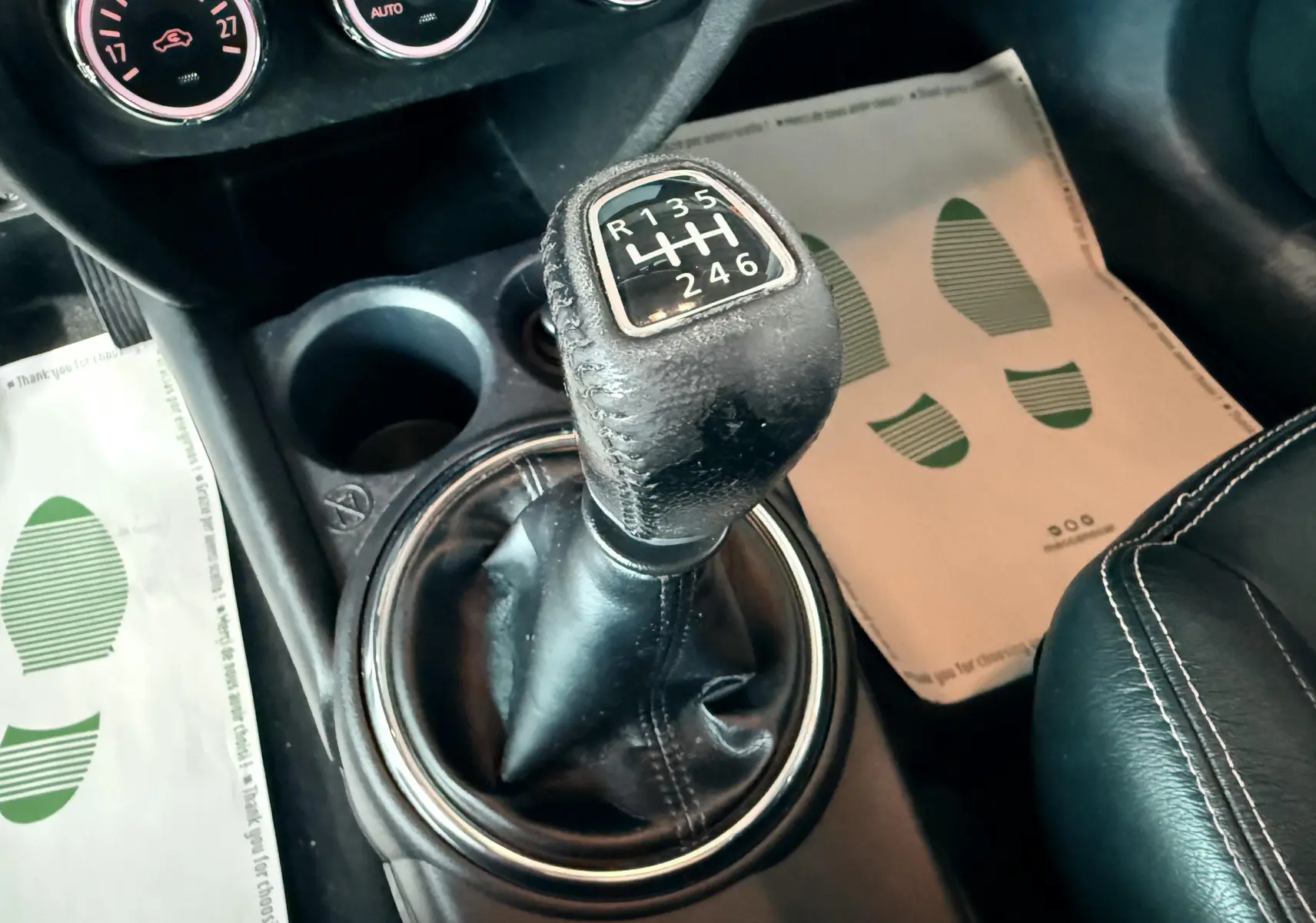 Gros plan sur le levier de vitesses manuel noir du Mitsubishi ASX 2015, avec console et partie du siège en cuir visible.