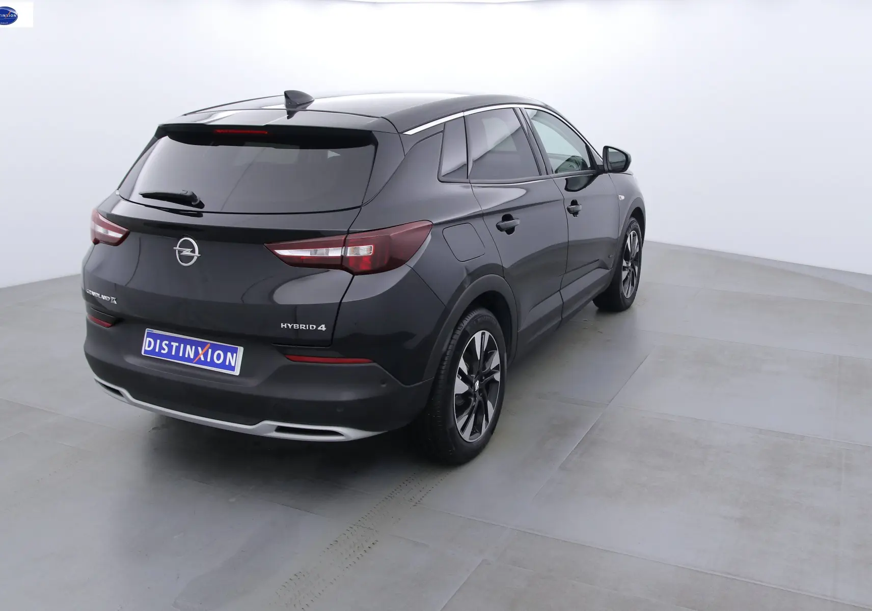 Opel Grandland X hybride rechargeable noir métal vu de 3/4 arrière droit avec jantes noires et grises.