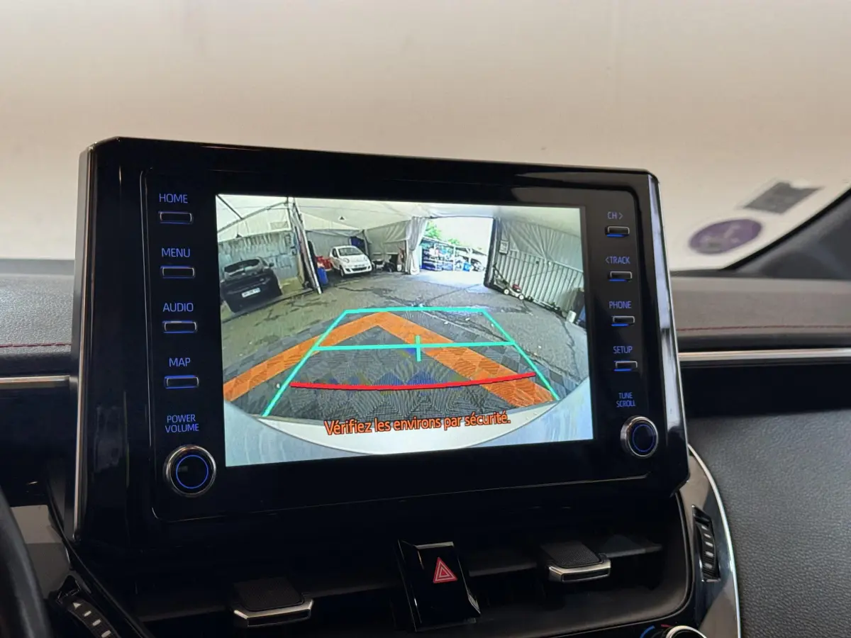 Écran tactile intérieur de la Toyota Corolla hybride 2021 affichant la caméra de recul avec lignes de guidage colorées.