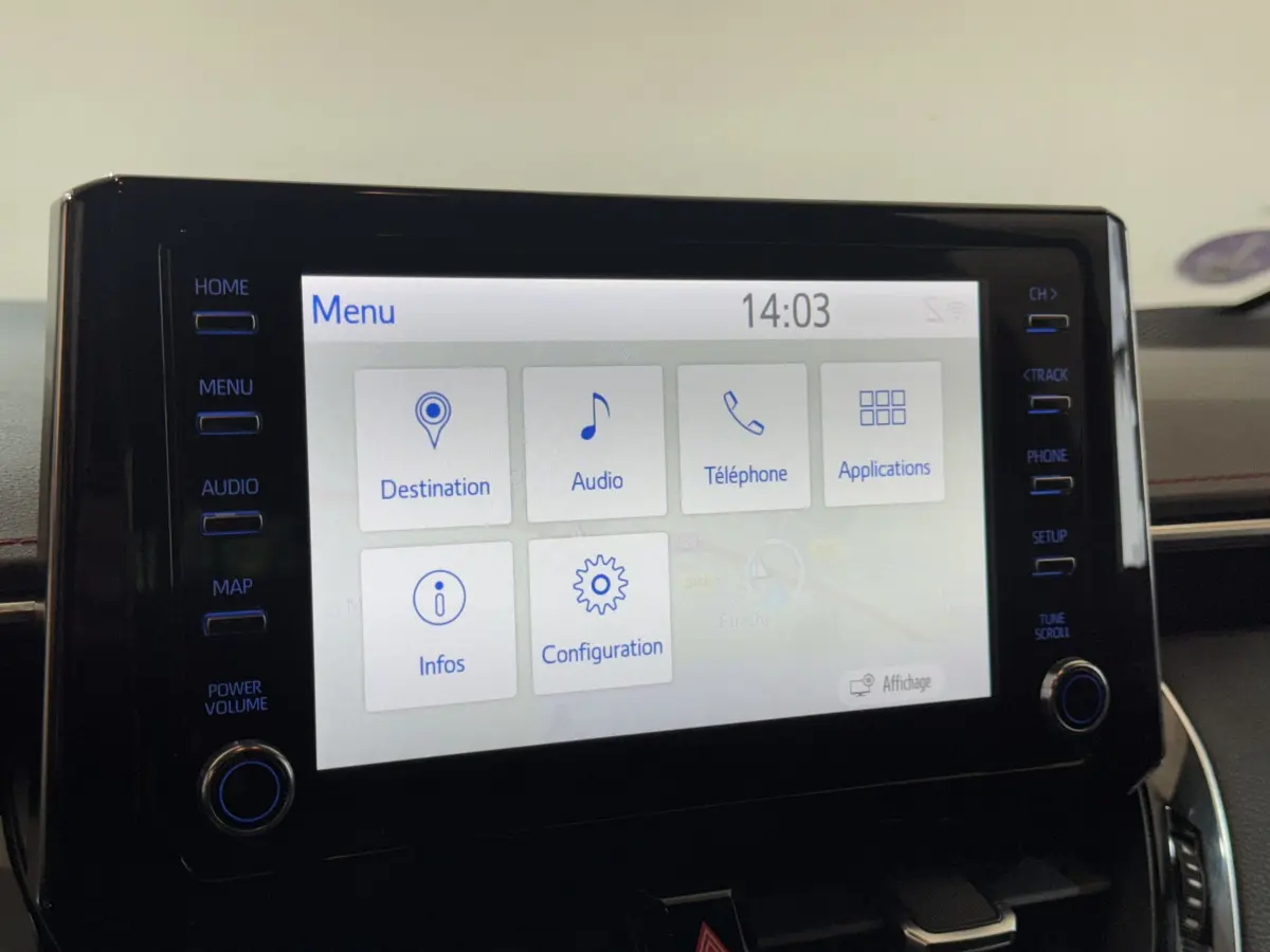 Écran tactile central de la Toyota Corolla Hybride 122h Collection 2021, affichage menu et commandes latérales.