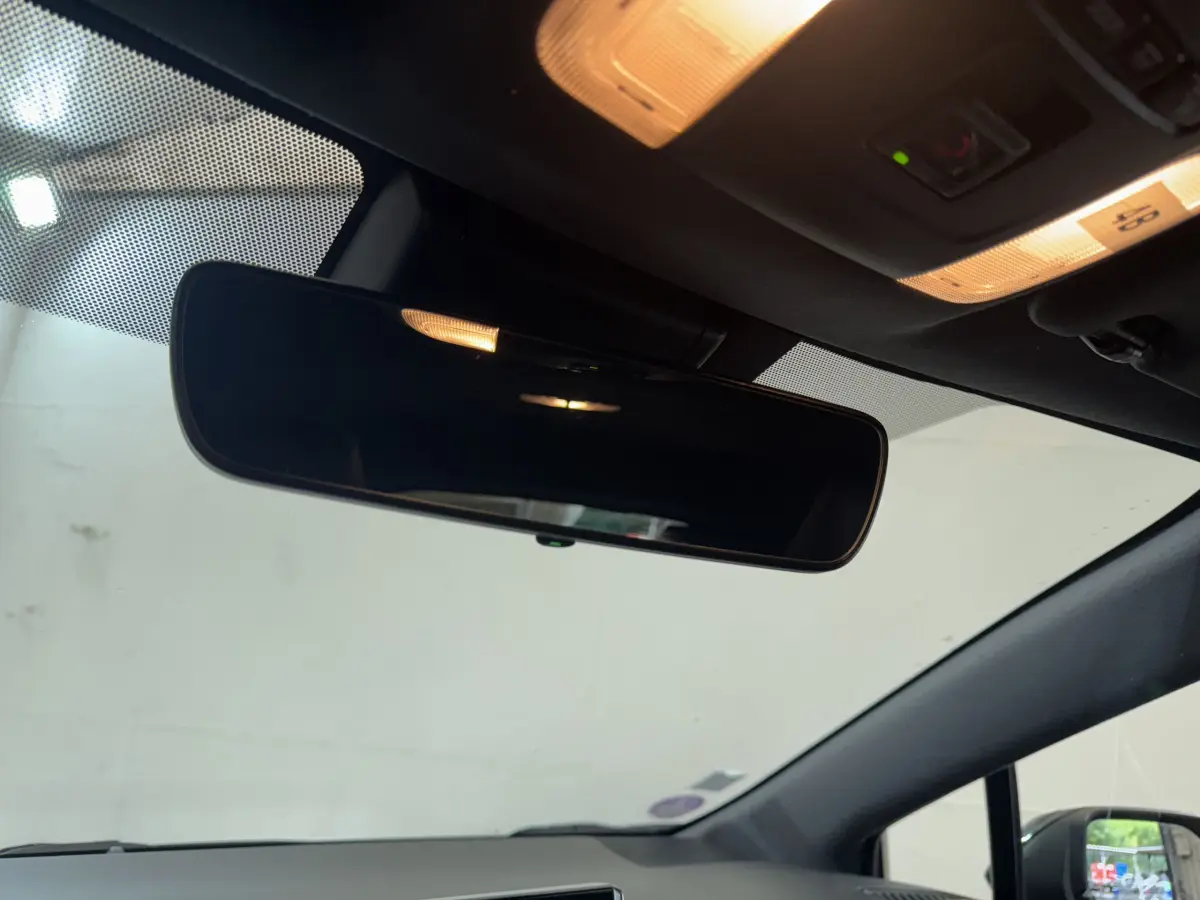 Vue intérieure du rétroviseur central et du plafonnier éclairé de la Toyota Corolla Hybride gris clair de 2021.