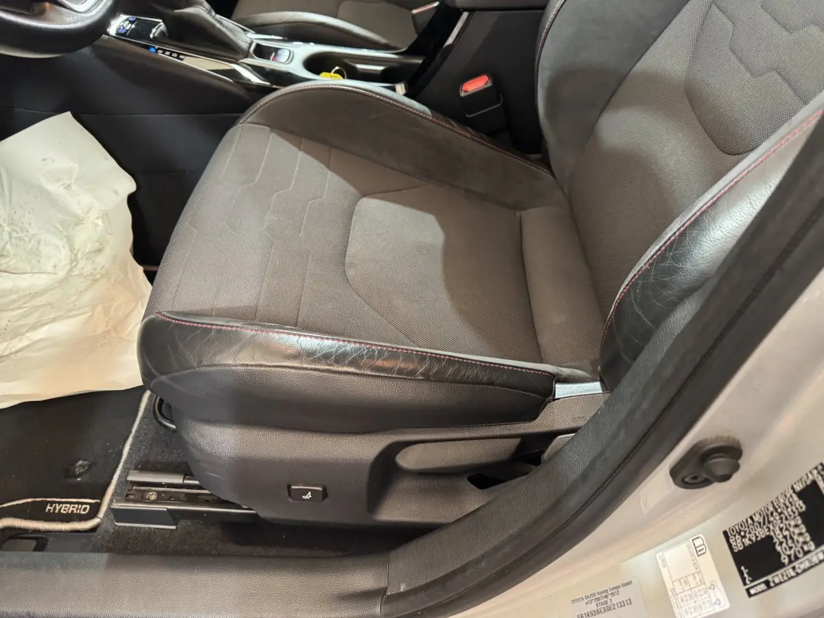 Vue rapprochée du siège conducteur gris et noir avec surpiqûres rouges de la Toyota Corolla Hybride 122h Collection 2021.