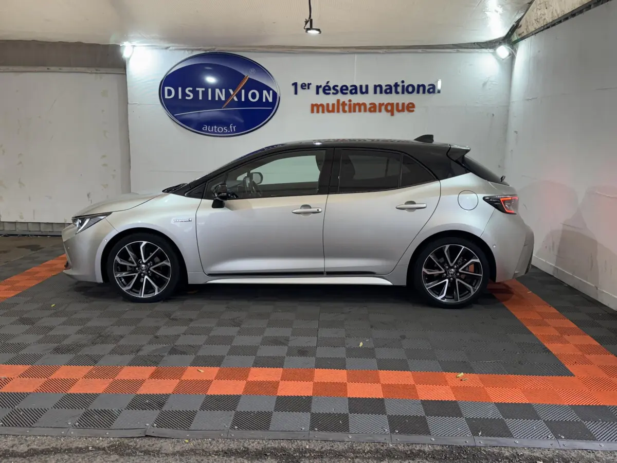 Vue latérale droite d'une Toyota Corolla Hybride 122h Collection gris clair avec toit noir et jantes alliage sport.