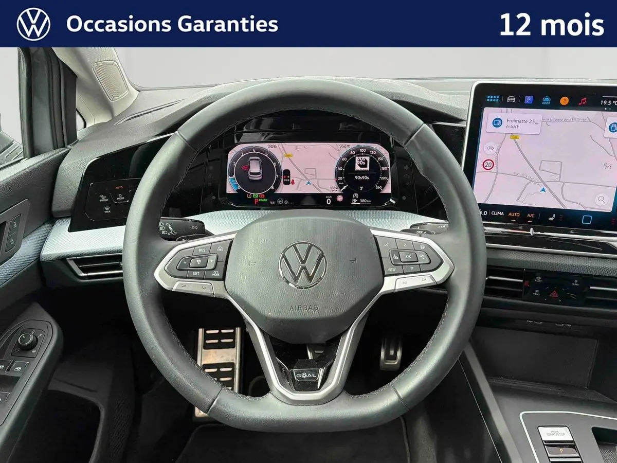 Vue intérieure centrée sur le volant noir de la Volkswagen Golf 1.5 eTSI 2025 avec écran digital et console tactile.