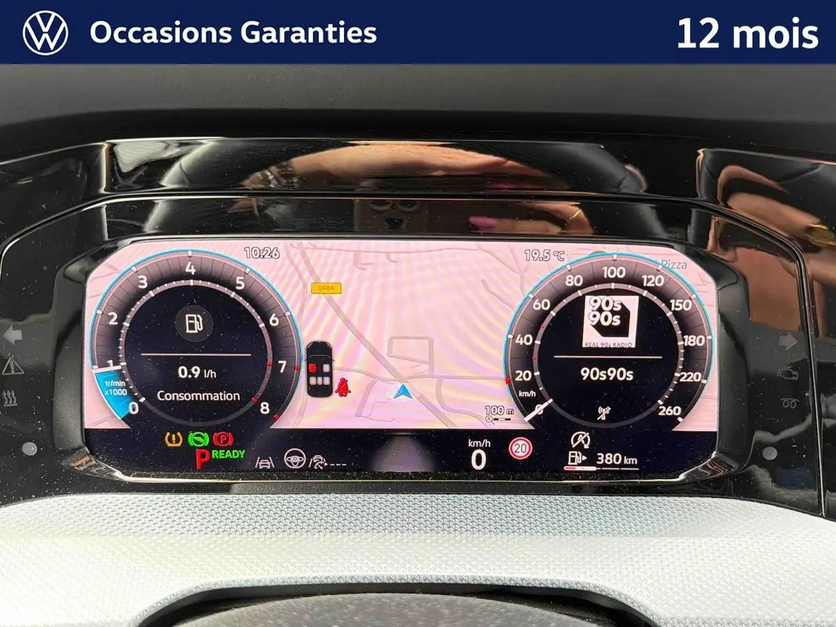 Vue rapprochée du combiné d'instruments digital de la Volkswagen Golf 2025 affichant la navigation et la consommation.