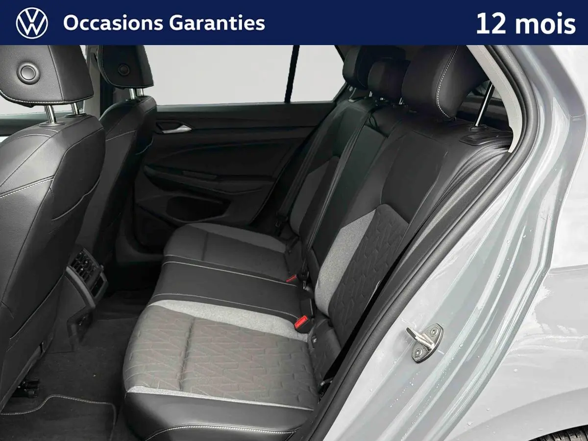 Vue intérieure côté droit sur la banquette arrière grise et noire de la Volkswagen Golf 1.5 eTSI 2025 avec porte ouverte.