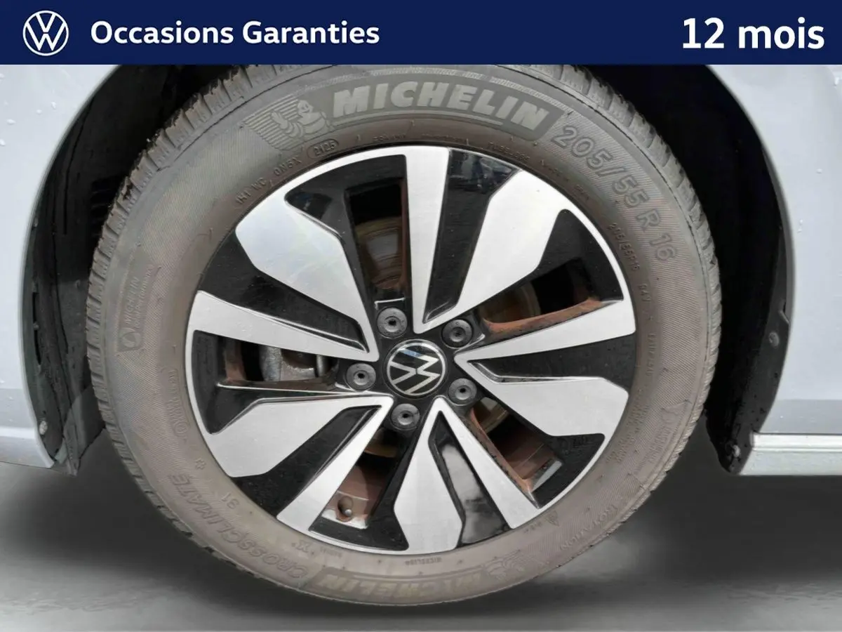 Gros plan sur la jante alliage 16'' Zurich bicolore et pneu Michelin 205/55 R16 d'une Volkswagen Golf grise.