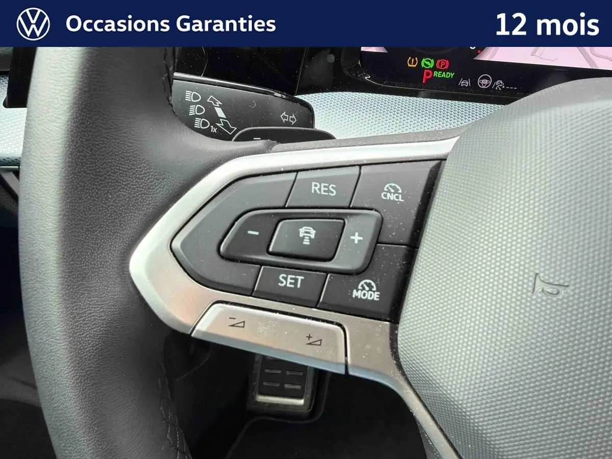 Gros plan sur le volant côté gauche de la Volkswagen Golf 2025, montrant les commandes du régulateur de vitesse et d'assistance.