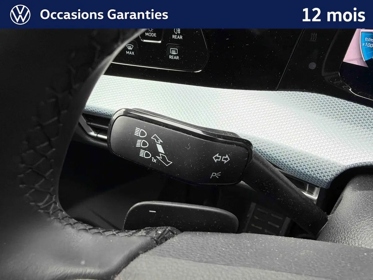 Gros plan sur la commande de clignotants et feux dans l’habitacle gris d’une Volkswagen Golf 1.5 eTSI 2025.