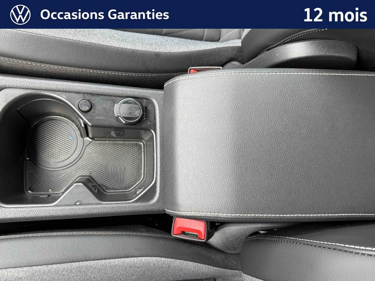 Vue rapprochée de la console centrale grise avec accoudoir et porte-gobelets du Volkswagen Golf 1.5 eTSI 2025.