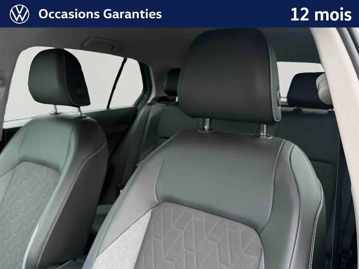Vue intérieure sur les sièges avant en cuir gris de la Volkswagen Golf 1.5 eTSI 2025, avec appuis-tête visibles.