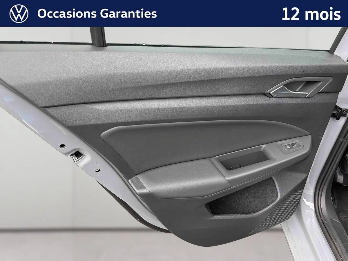 Porte arrière droite ouverte de la Volkswagen Golf 1.5 eTSI 2025 gris, montrant le panneau intérieur gris avec commande de vitre.