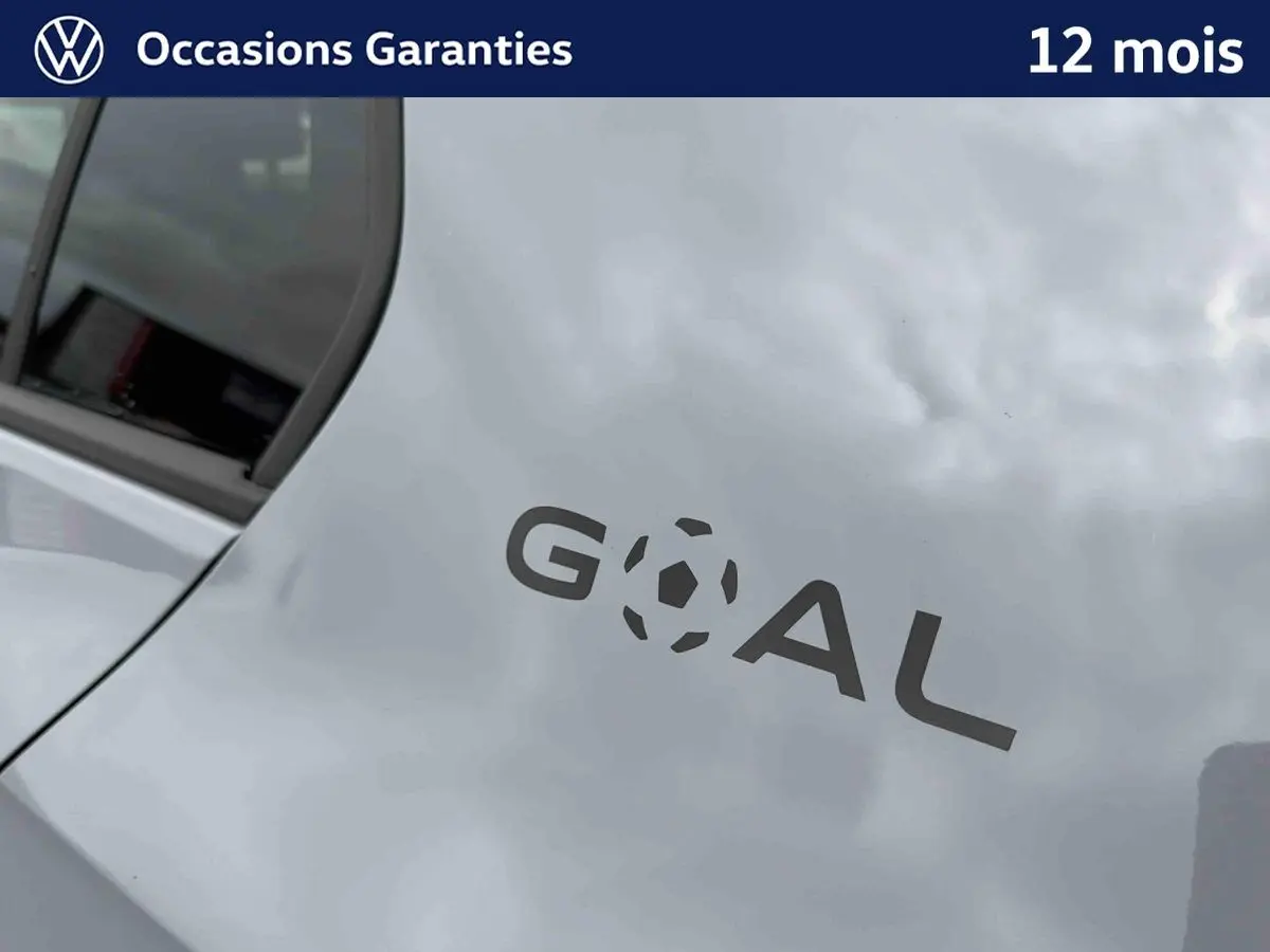 Gros plan sur l'arrière gris d'une Volkswagen Golf avec logo "GOAL" stylisé en noir sur la carrosserie.