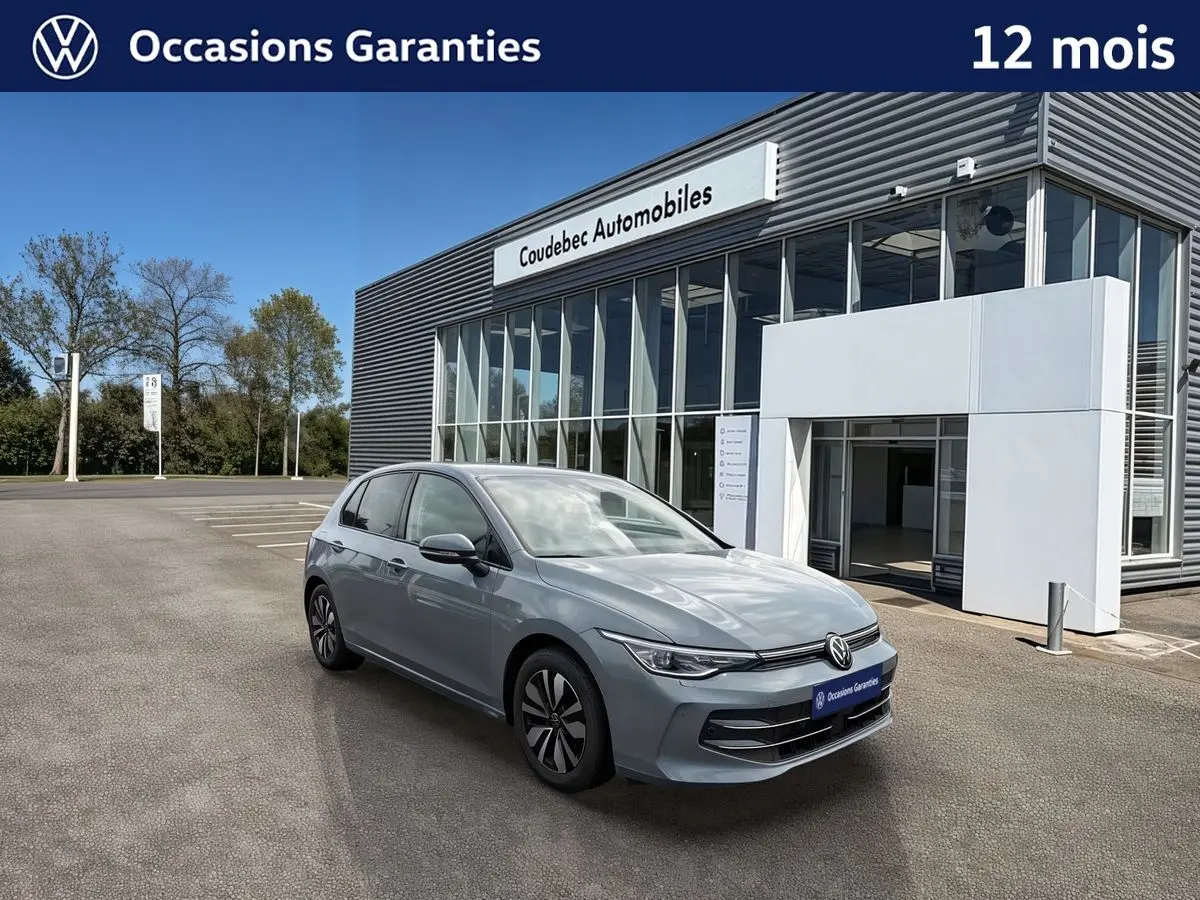 Volkswagen Golf 1.5 eTSI gris vue 3/4 avant, avec jantes alliage et projecteurs Matrix LED, devant un concessionnaire.