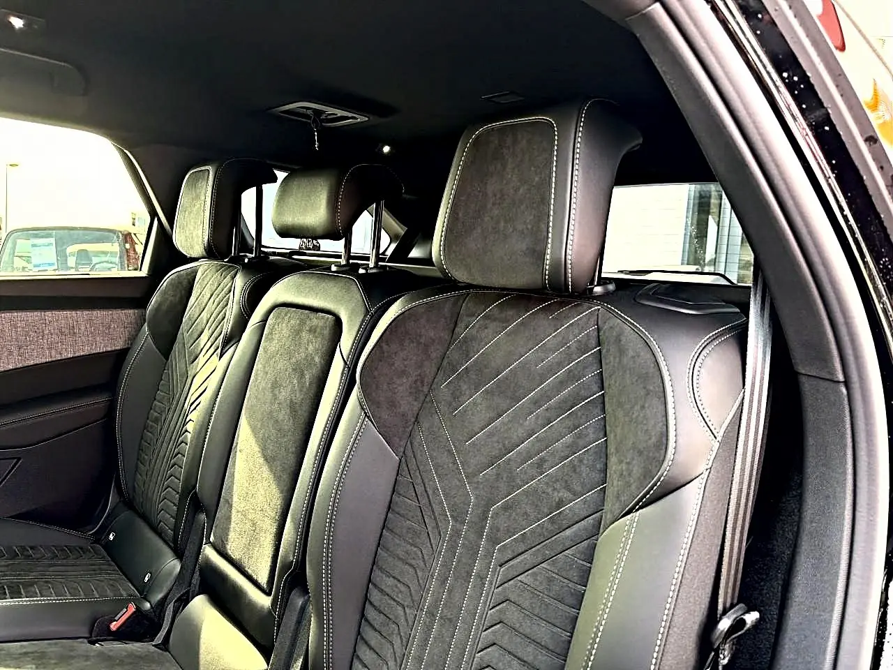 Vue intérieure côté droit sur les sièges arrière noirs en cuir et alcantara du Peugeot 5008 Hybrid 145 GT 2025.