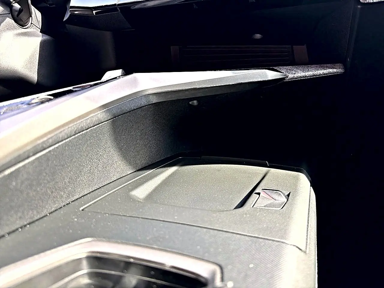 Gros plan sur la boîte à gants fermée côté passager du Peugeot 5008 noir, intérieur moderne et épuré.
