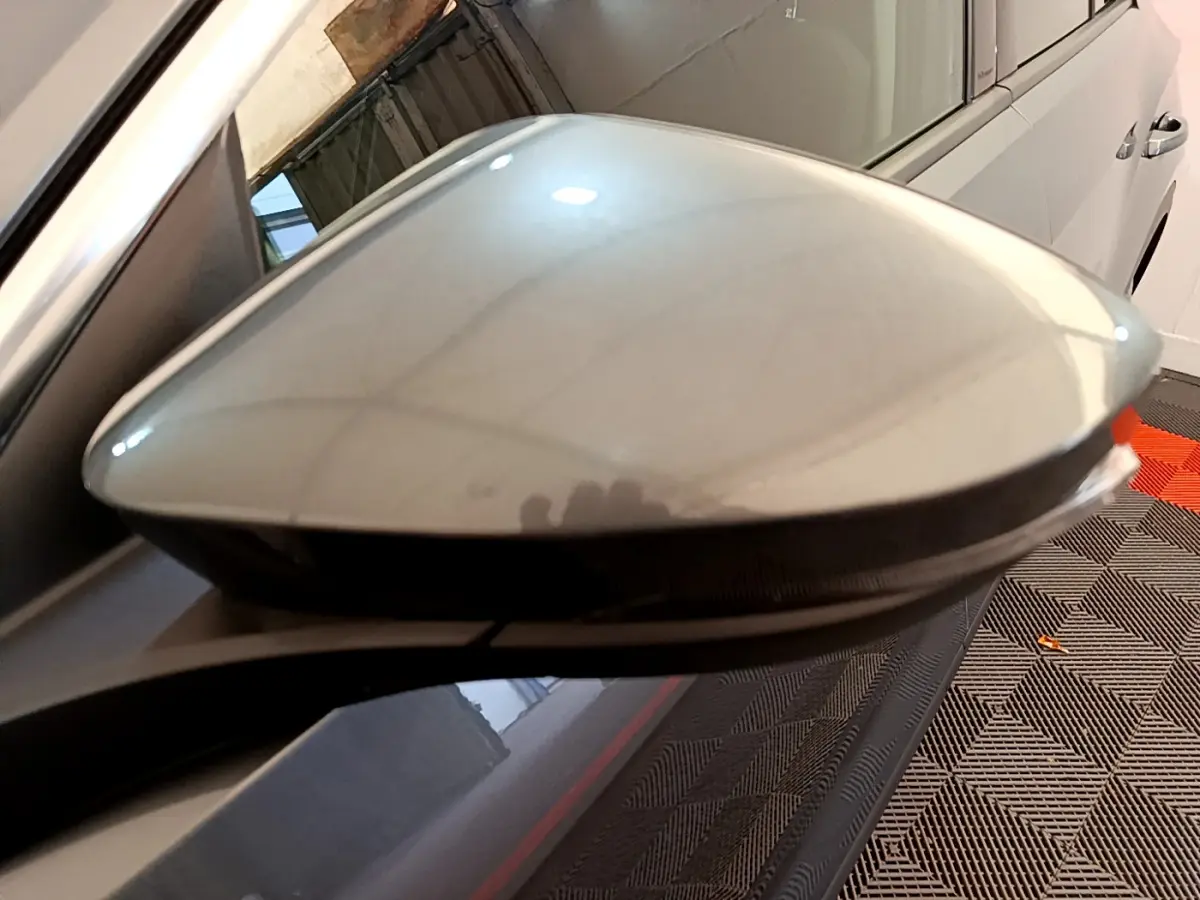 Gros plan sur le rétroviseur droit gris clair du Volkswagen T-Roc 1.0 TSI 110 Lounge Business, avec clignotant intégré.