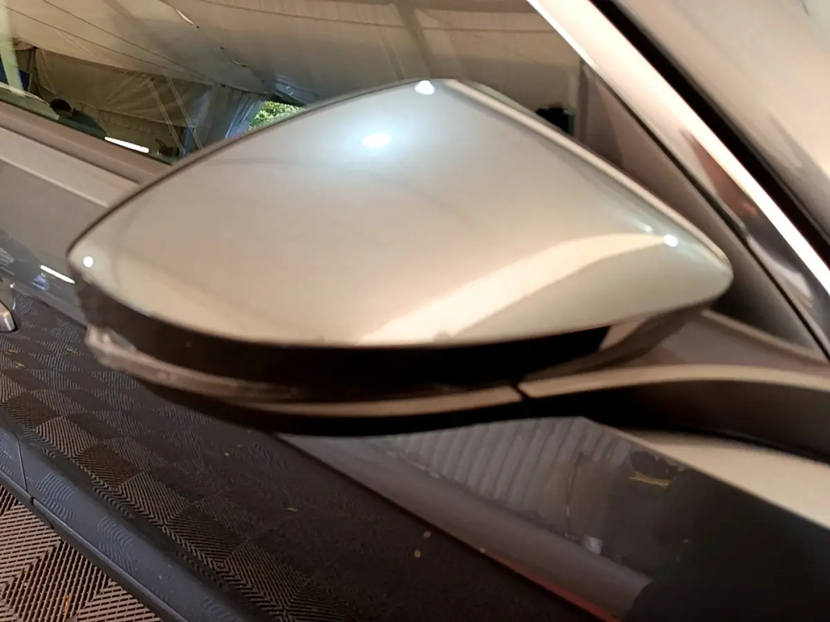 Gros plan sur le rétroviseur droit gris clair du Volkswagen T-Roc 2021, avec clignotant intégré.