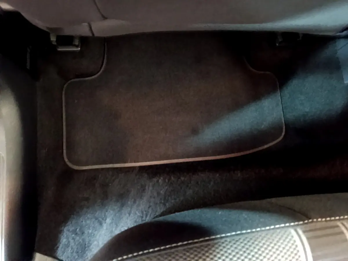 Vue rapprochée du tapis de sol noir côté passager avant du Volkswagen T-Roc gris foncé 2021.