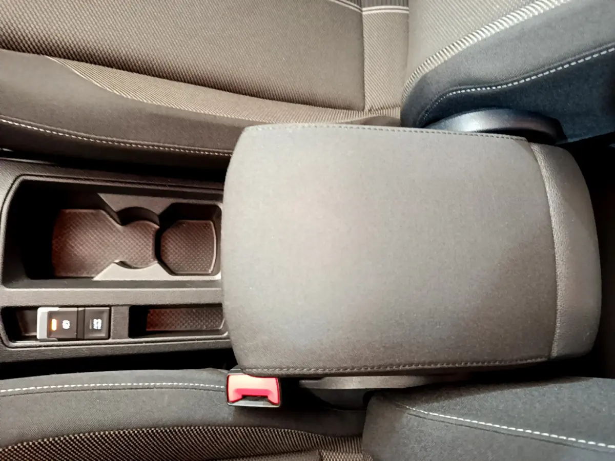 Gros plan sur l'accoudoir central gris foncé et les porte-gobelets du Volkswagen T-Roc 1.0 TSI 110 Lounge Business.