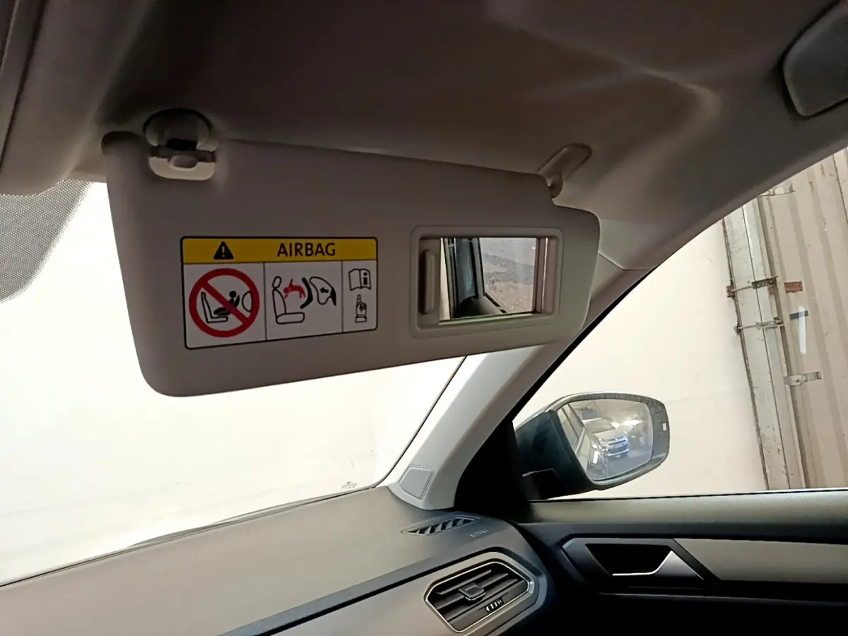 Vue intérieure côté conducteur du Volkswagen T-Roc gris foncé 2021, avec pare-soleil et rétroviseur latéral visible.