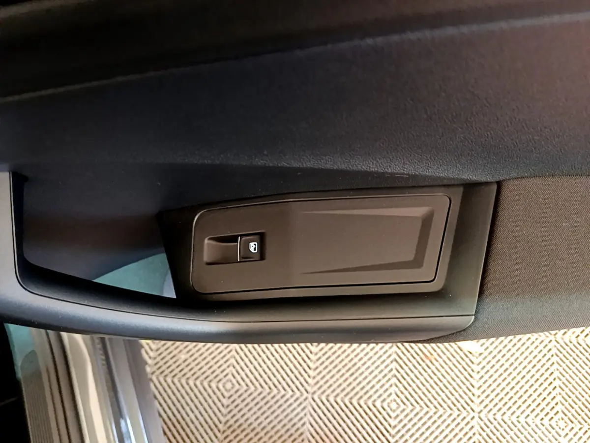 Détail de la poignée intérieure de porte côté conducteur du Volkswagen T-Roc gris foncé, vue rapprochée.