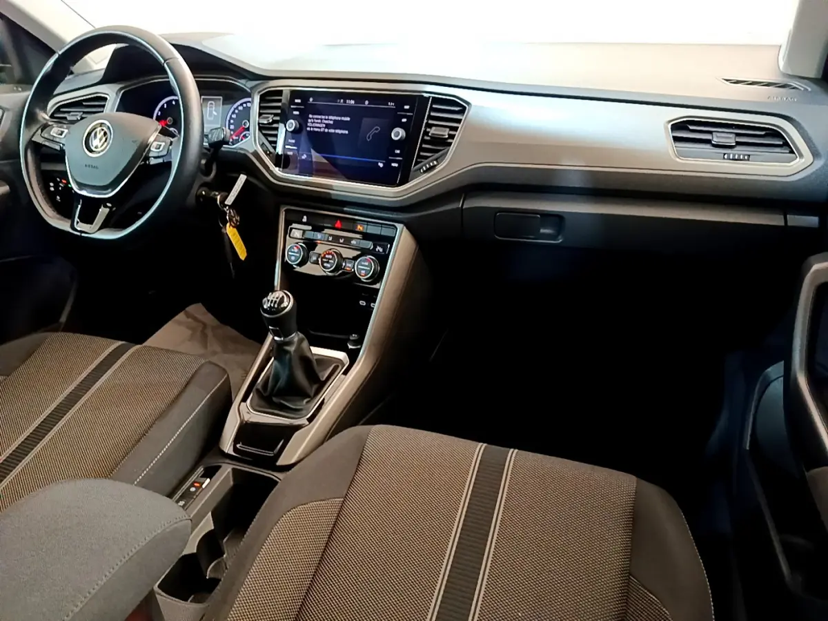 Vue intérieure avant du Volkswagen T-Roc 1.0 TSI 110 Lounge Business, montrant le tableau de bord et la boîte manuelle.
