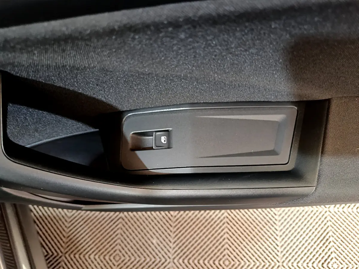 Gros plan sur la commande de verrouillage électrique sur la porte intérieure côté conducteur du Volkswagen T-Roc gris foncé.