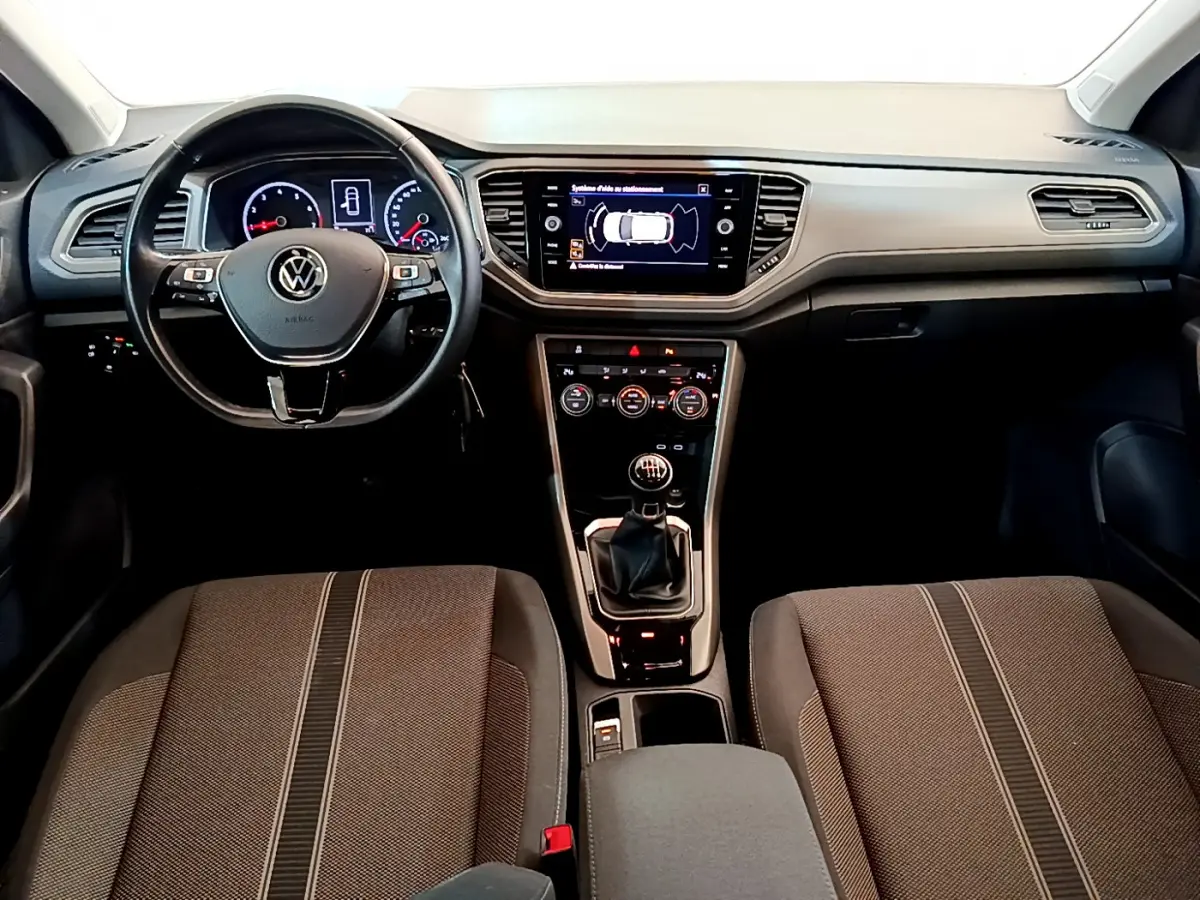 Vue intérieure avant du Volkswagen T-Roc 1.0 TSI 110 Lounge Business 2021, tableau de bord et volant cuir noir.