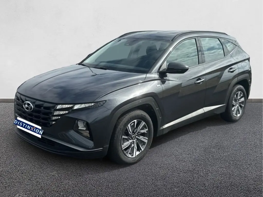 Hyundai Tucson gris 2023 en 3/4 avant droit, avec calandre distinctive et jantes alliage modernes.