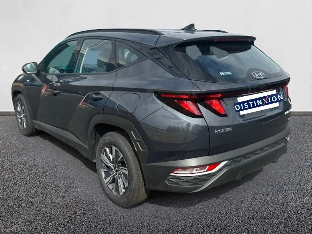 Vue 3/4 arrière droite du Hyundai Tucson gris 2023 avec feux arrière LED et jantes alliage distinctives.