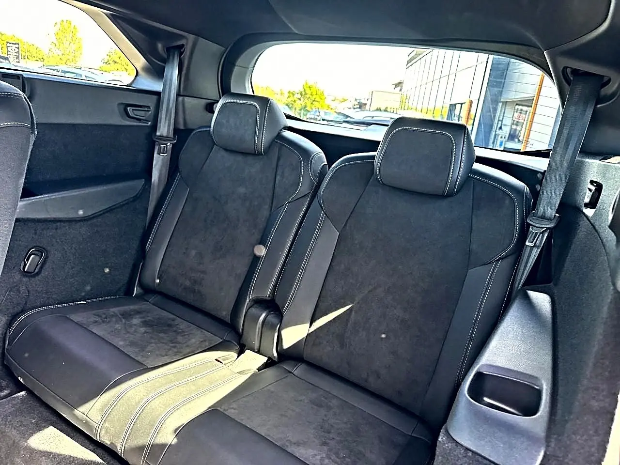 Vue intérieure sur les deux sièges arrière supplémentaires noirs avec surpiqûres blanches du Peugeot 5008 Hybrid 145 GT 2025.