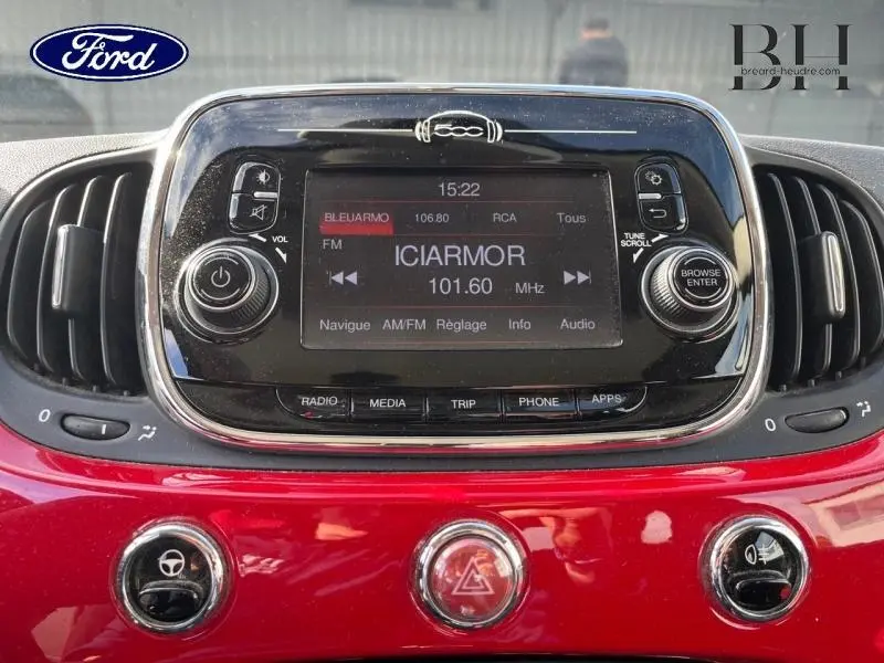 Vue rapprochée du tableau de bord noir et rouge de la Fiat 500 avec écran tactile et commandes circulaires.