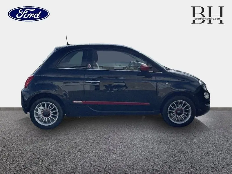 Profil droit d'une FIAT 500 noire avec détails rouges sur les bas de porte et rétroviseur, jantes alu visibles.