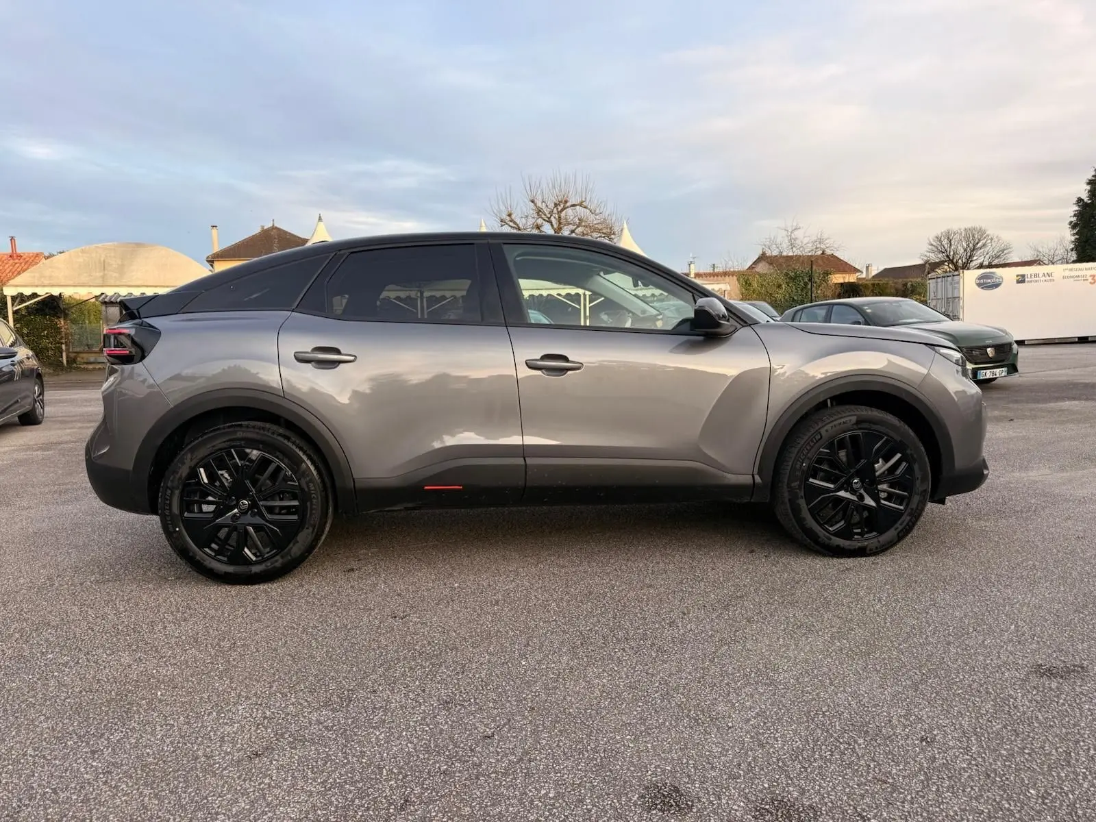 Vue de profil côté droit d'une Citroën C4 hybride 2025 gris Mercury avec toit noir et jantes noires.