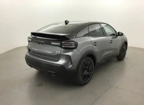Vue 3/4 arrière droite d'une Citroën C4 hybride 2025 gris Mercury avec jantes noires et feux arrière LED fumés.
