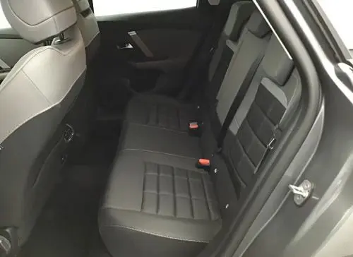 Vue intérieure du siège arrière droit du Citroën C4 hybride gris Mercury, montrant les assises en tissu et les ceintures de sécurité.