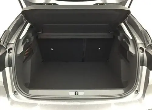 Coffre ouvert vu de l'arrière d'une Citroën C4 hybride 2025 gris Mercury, montrant l'espace de chargement vide.