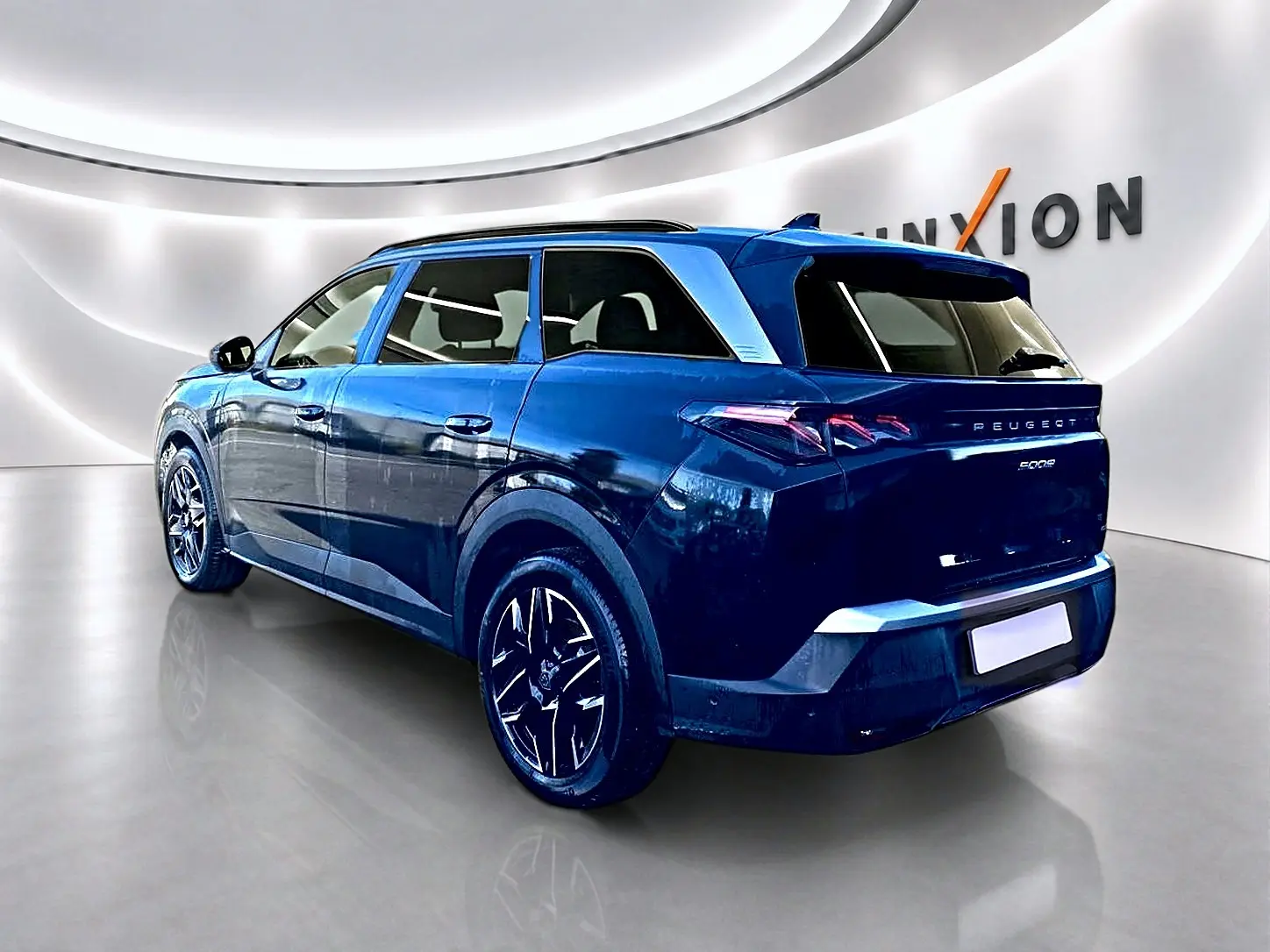 Peugeot 5008 noir vue 3/4 arrière droit dans un showroom lumineux avec jantes alliage noires.