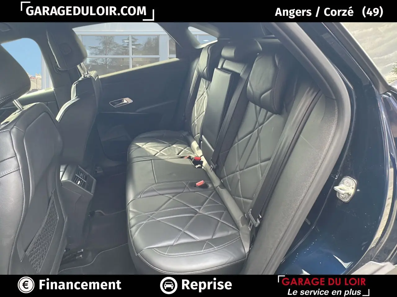 Vue intérieure sur la banquette arrière en cuir noir matelassé du DS7 bleu saphir, avec portières ouvertes côté droit.