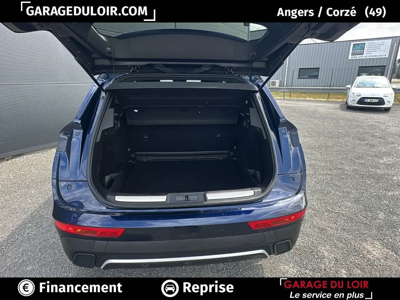 Vue arrière d'un DS7 bleu saphir avec coffre ouvert montrant un espace de chargement spacieux et un pare-chocs noir avec insert chromé.